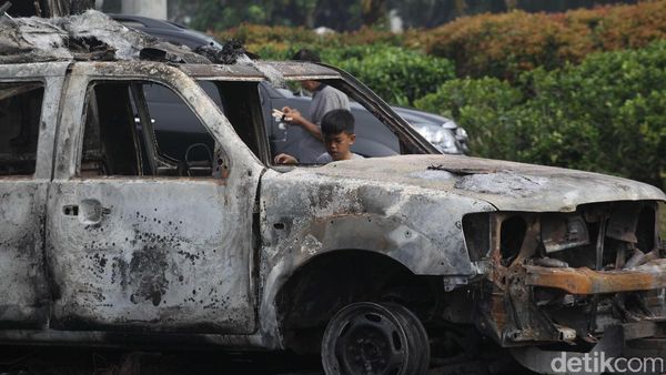 Dua Bangkai Mobil Aparat Yang Dibakar Massa Jadi Tontonan Warga