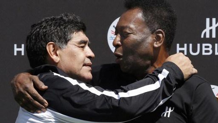 Former Argentinian football international Diego Maradona (L) and former Brazilian footballer Pele pose after a football match organised by Swiss luxury watchmaker Hublot at the Jardin du Palais Royal in Paris on June 9, 2016, on the eve of the Euro 2016 European football championships. / AFP PHOTO / PATRICK KOVARIK