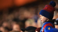 Seorang bocah pendukung Crystal Palace menyembul di antara kerumuman suporter tuan rumah saat menjamu Manchester City. (Foto: Stephen Pond/Getty Images)