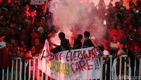 Suporter menyalakan kembang api.