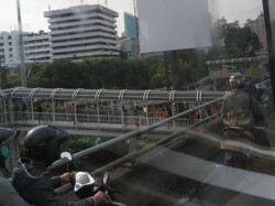 Pria Ini Panjat Baliho di Perempatan Grogol Sambil Kibarkan Merah Putih