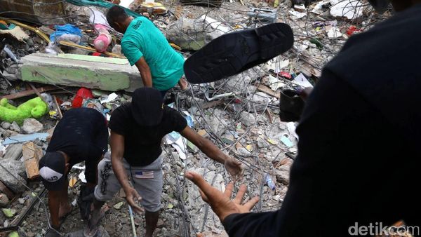 Warga Evakuasi Barang yang Tertimbun Reruntuhan