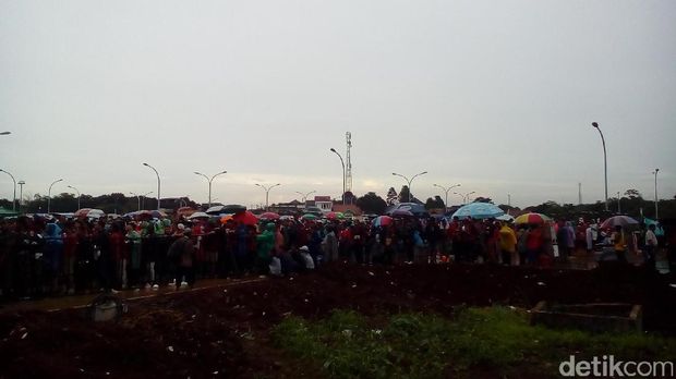 Suporter Timnas Mengantre Masuk Stadion Pakansari di Bawah Guyuran Hujan