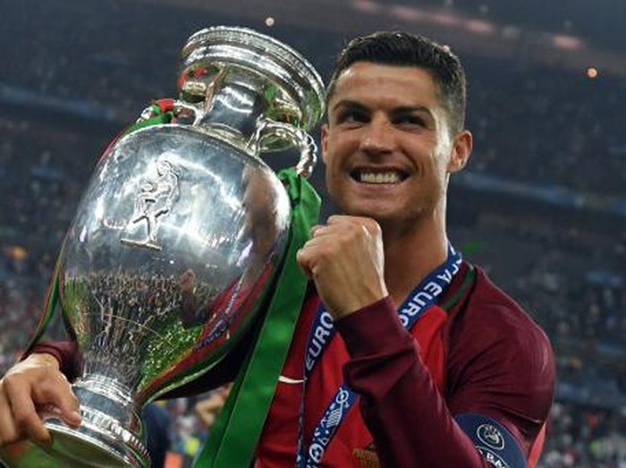 Portugal's forward Cristiano Ronaldo smiles while posing with the trophy after Portugal won the Euro 2016 final football match between Portugal and France at the Stade de France in Saint-Denis, north of Paris, on July 10, 2016. / AFP PHOTO / FRANCISCO LEONG