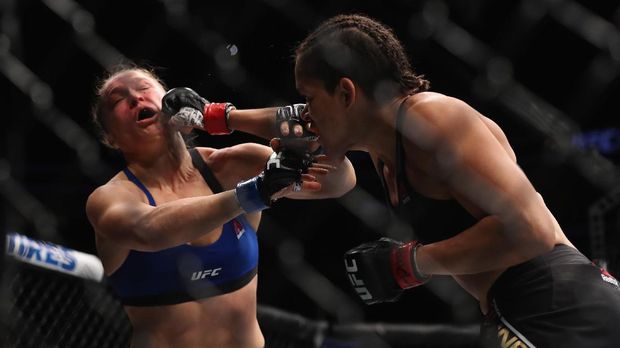 LAS VEGAS, NV - DECEMBER 30: (R-L) Amanda Nunes of Brazil punches Ronda Rousey in their UFC women's bantamweight championship bout during the UFC 207 event on December 30, 2016 in Las Vegas, Nevada. Christian Petersen/Getty Images/AFP