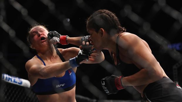 LAS VEGAS, NV - DECEMBER 30: (R-L) Amanda Nunes of Brazil punches Ronda Rousey in their UFC women's bantamweight championship bout during the UFC 207 event on December 30, 2016 in Las Vegas, Nevada.   Christian Petersen/Getty Images/AFP