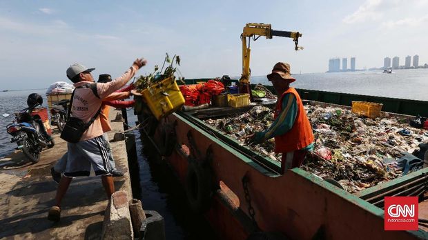 SAMPAH TELUK JAKARTA Petugas kebersihan memindahkan sampah dari pinggir laut ke dalam kapal sampah di Pelabuhan Kali Adem, Jakarta Utara, Senin, 2 Januari 2017. CNN Indonesia/Safir Makki