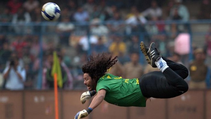 Former Colombian goolkeeper Rene Higuita kicks the ball to save a goal during an exhibition match between the Brazilian Masters and Indian All Stars in Kolkata on December 8, 2012. The Brazilian team won the match by 3-1. AFP PHOTO/ Dibyangshu SARKAR / AFP PHOTO / DIBYANGSHU SARKAR