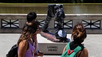 Warga melintas di depan patung Lionel Messi yang dirusak orang tak bertangung jawab. REUTERS/Marcos Brindicci.