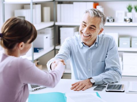 Businesswoman Interviewing Male Candidate For Job Holding Pen With Digital Tablet On Table
