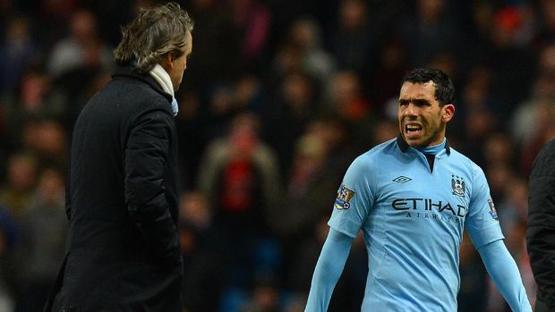Manchester City's Argentinian forward Carlos Tevez (R) speaks to Manchester City's Italian manager Roberto Mancini (L) after being substituted during the English FA Cup quarter-final football match between Manchester City and Barnsley at the Etihad Stadium in Manchester, north-west England, on March 9, 2013. Manchester City won 5-0. AFP PHOTO/ANDREW YATESRESTRICTED TO EDITORIAL USE. No use with unauthorized audio, video, data, fixture lists, club/league logos or “live” services. Online in-match use limited to 45 images, no video emulation. No use in betting, games or single club/league/player publications. / AFP PHOTO / ANDREW YATES