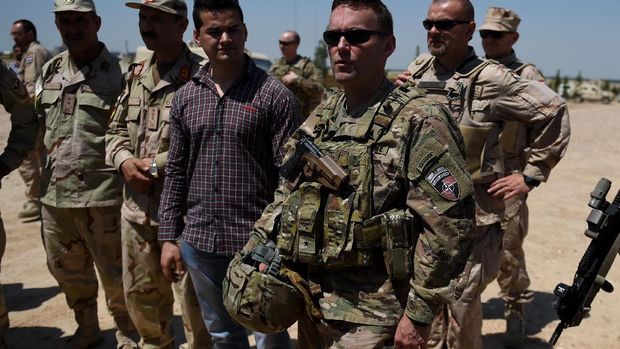 Resolute support spokesman Brigadier General H.Cleveland (R) talks with an Afghan National Army (ANA) soldier at the Shaheen 209th military corps training center in Mazar-i-Sharif on April 26, 2016. There are around 13,000 NATO troops stationed in Afghanistan, officially in a training and advisory role since the end of their combat mission in 2014.  / AFP PHOTO / WAKIL KOHSAR
