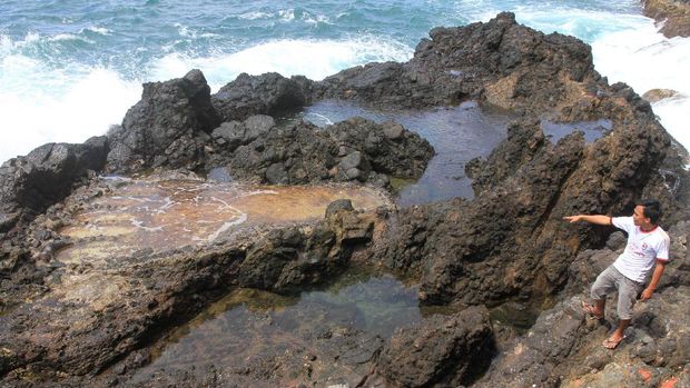 Seorang warga menunjukkan bekas tapak kaki raksasa di kawasan objek wisata Tapak dan Tuan yang berarti Tapak Kaki Tuan Tapa di Desa Gampong Pasar, Tapaktuan, Aceh Selatan, Aceh, Kamis (19/1). Objek wisata bekas tapak kaki raksasa sang tuan tapa yang berukuran panjang 4 meter dan lebar 2 meter itu merupakan salah satu objek wisata sejarah munculnya kota Tapaktuan pada tahun 1980 yang ramai dikunjungi oleh wisatawan lokal maupun asing. ANTARA FOTO/Syifa Yulinnas/pd/17.