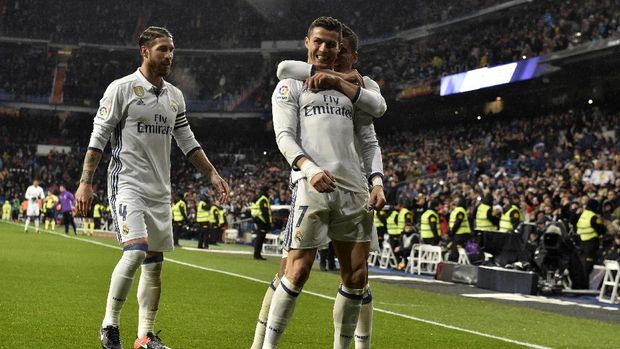 Real Madrid's Portuguese forward Cristiano Ronaldo (C) is congratulated by Real Madrid's defender Sergio Ramos (L) and Real Madrid's Brazilian midfielder Casemiro after scoring a goal during the Spanish league football match Real Madrid CF vs Real Sociedad at the Santiago Bernabeu stadium in Madrid on January 29, 2017. / AFP PHOTO / GERARD JULIEN