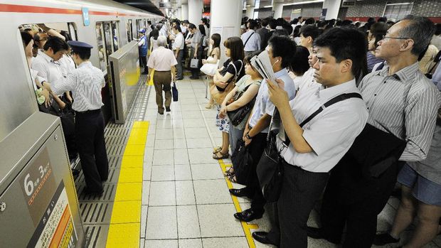 TO GO WITH Japan-transport-leisure-tourism-subway,FEATURE by Hiroshi HIYAMAThis photo taken on July 12, 2013 shows people waiting in line for the next subway train on the Marunouchi Line during the morning rush hour at Ikebukuro Station in Tokyo.  The vast train network that criss-crosses subterranean Tokyo can be a confusing and intimidating place for the uninitiated. The city actually has two public subway operators: Tokyo Metro and Toei Subway, and between them they carry nearly 10 million passengers daily.           AFP PHOTO / Toru YAMANAKA / AFP PHOTO / TORU YAMANAKA