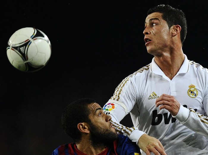 BARCELONA, SPAIN - JANUARY 25:  Dani Alves of FC Barcelona (L) duels for a high ball with Cristiano Ronaldo of Real Madrid CF during the Copa del Rey quarter final second leg match between FC Barcelona and Real Madrid at Camp Nou on January 25, 2012 in Barcelona, Spain.  (Photo by David Ramos/Getty Images)