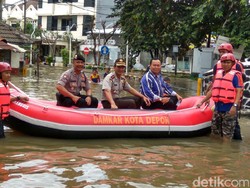 Polisi Bantu Seberangkan Warga yang Terdampak Banjir di Depok