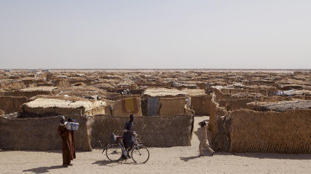 A displaced man rides bicycle in a camp for internally displaced people at Monguno district of Borno State on February 14, 2017.The Nigerian airforce has constructed a makeshift runway as part of military tactics to counter Boko Haram insurgency and to accelerate distribution of relief materials by donor agencies to internaly displaced people in north-eastern Nigeria, where the conflict with Boko Haram has killed at least 20,000 people and left more than 2.6 million homeless in its six-year insurgency.   / AFP PHOTO / FLORIAN PLAUCHEUR