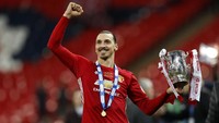 Zlatan Ibrahimovic menunjukkan trofi sambil mengepalkan tangan. Dalam pertandingan ini, Ibrahimovic menjadi penentu kemenangan MU. Dia mengubah kedudukan menjadi 3-2 di menit 86 melalui tandukan dari jarak dekat. Pool/Darren Staples/Reuters/detikFoto.