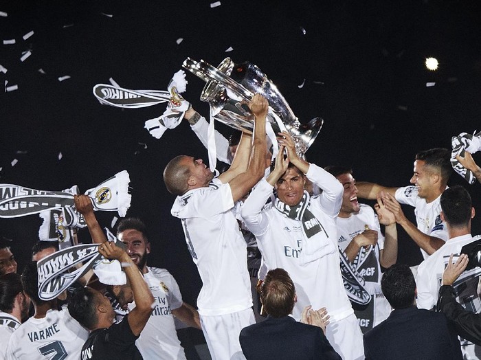 MADRID, SPAIN - MAY 29: Pepe of Real Madrid CF stand the trophy behind his teammate aCristiano Ronaldo as they celebrate with their fans at Santiago Bernabeu Stadium the day after winning the UEFA Champions League Final match against Club Atletico de Madrid on May 29, 2016 in Madrid, Spain. Real Madrid CF is the only European football team with 11 European Cups (Photo by Gonzalo Arroyo Moreno/Getty Images)