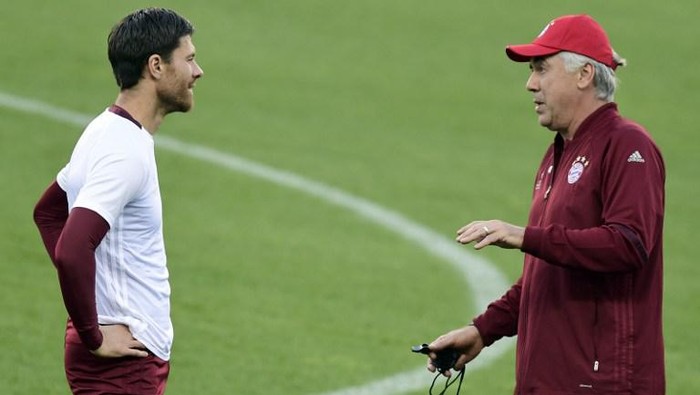 Ancelotti Alonso Bayern Munichs Italian head coach Carlo Ancelotti (R) talks to Bayern Munichs Spanish midfielder Xabi Alonso during a training session at the Vicente Calderon stadium in Madrid on September 27, 2016 on the eve of their UEFA Champions league match against Atletico de Madrid. / AFP PHOTO / JAVIER SORIANO