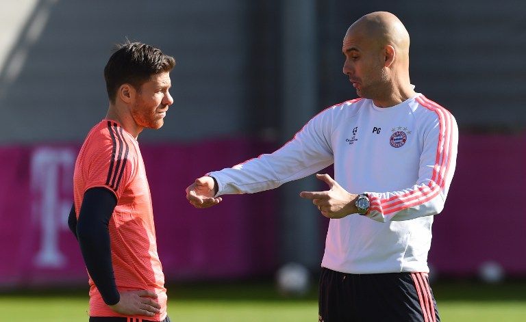 Bayern Munich's Spanish head coach Pep Guardiola (R) talks with Bayern Munich's Spanish midfielder Xabi Alonso (L) during the last team trainings session one day before the Champions League last 16, first-leg match between Juventus Turin and Bayern Munich at the trainings field in Munich, southern Germany, on February 22, 2016. / AFP PHOTO / CHRISTOF STACHE