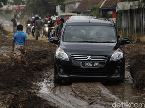 Warga Nekat Terobos Lumpur di Jalan Bojong Majalaya