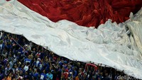 Suporter Arema FC membentangkan bendera merah putih raksasa di tribun Stadion Pakansari.