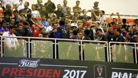 Jokowi mengalungkan medali kepada para pemain Arema FC.  