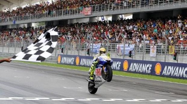 CORRECTING DETAILWorld Champion Italian rider Valentino Rossi of Fiat Yamaha celebrates defending his seventh Moto GP title the Malaysian Motocycle Grand Prix at the Sepang racing circuit on October 25, 2009. Defending world champion Rossi claimed the victory in wet track conditions, while Australian Casey Stoner won the Malaysian MotoGP race. The 30-year-old Rossi secured the title despite only coming in third. Spain's Dani Pedrosa was second. AFP PHOTO/SAEED KHAN / AFP PHOTO / SAEED KHAN