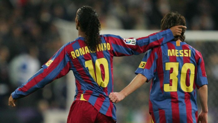 MADRID, SPAIN - NOVEMBER 19:  Ronaldinho (L) of  Barcelona celebrates with Lionel Messi after scoring a goal during the Primera Liga match between Real Madrid and F.C. Barcelona at the Bernabeu on November 19, 2005 in Madrid, Spain.  (Photo by Denis Doyle/Getty Images)