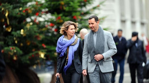 Syrian president Bashar al-Assad and his wife Asma walk in a street of Paris on December 10, 2010. Al-Assad is on a two-days official visit to France.  AFP PHOTO MIGUEL MEDINA / AFP PHOTO / MIGUEL MEDINA