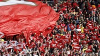 Fans membentangkan bendera raksasa untuk menyemangati para pemain Arsenal. Reuters/Carl Recine.