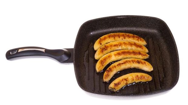 fried bananas on a frying pan on the isolated background