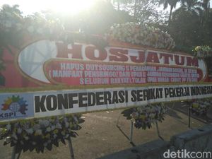 Massa Buruh Pakai Karangan Bunga untuk Sampaikan Tuntutan