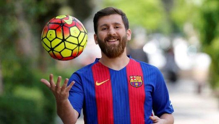 Reza Parastesh, a doppelganger of Barcelona and Argentinas footballer Lionel Messi, poses for a picture in a street in Tehran on May 8, 2017. / AFP PHOTO / ATTA KENARE