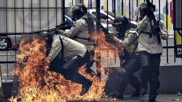 Sekelompok polisi dilempar bom molotov dalam kerusuhan di Venezuela, Mei.