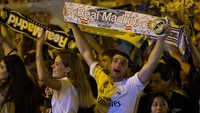 Fans membentangkan syal sebagai bentuk kegembiraan mereka menyambut kemenangan Real Madrid. Paul Hanna/Reuters.