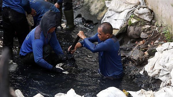 Pasukan Biru Nyemplung ke Got Hitam untuk Bersihkan Lumpur