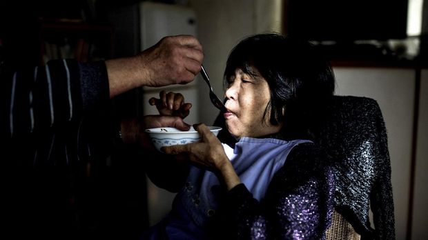 In this picture taken on January 10, 2017, Kanemasa Ito (L) feeds his dementia-stricken wife Kimiko at their house in Kawasaki.One of the world's most rapidly aging and long-lived societies, Japan is at the forefront of an impending global healthcare crisis. Authorities are bracing for a dementia timebomb and their approach could shape policies well beyond its borders. / AFP PHOTO / BEHROUZ MEHRI / TO GO WITH Japan-society-ageing-dementia,FEATURE by Natsuko FUKUE