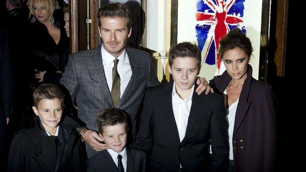 David and Victoria Beckham pose on the red carpet with three of their children, (L-R) Romeo, Cruz and Brooklyn as they arrive for the premiere of the Spice Girls musical 