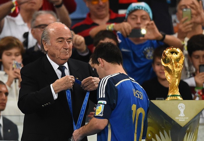 Lionel Messi RIO DE JANEIRO, BRAZIL - JULY 13: FIFA President Joseph S. Blatter presents Lionel Messi of Argentina with his second place medal after being defeated by Germany 1-0 in extra time during the 2014 FIFA World Cup Brazil Final match between Germany and Argentina at Maracana on July 13, 2014 in Rio de Janeiro, Brazil. (Photo by Laurence Griffiths/Getty Images)