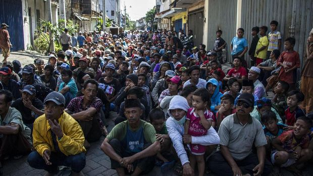 Warga kurang mampu berkumpul untuk mendapatkan zakat jelang Idul Fitri, di Surabaya, 2017.