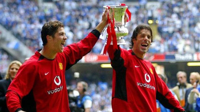 Manchester United's Cristiano Ronaldo (L) and Ruud Van Nistelrooy carry the FA Cup after their FA Cup Final victory over Millwall 22 May, 2004 in Cardiff, Wales. Manchester United won the FA Cup for the 11th time with a score of 3-0.     AFP PHOTO/JIM WATSON / AFP PHOTO / POOL / JIM WATSON