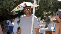 Gaya asyik Juergen Klopp saat liburan di Ibiza dengan menggunakan topi payung ini menjadi viral di media sosial (Foto: Daily Mail)