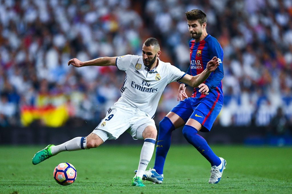 MADRID, SPAIN - APRIL 23:  Karim Benzema of Real Madrid CF competes for the ball with Gerard Pique of FC Barcelona during the La Liga match between Real Madrid CF and FC Barcelona at the Santiago Bernabeu stadium on April 23, 2017 in Madrid, Spain.  (Photo by David Ramos/Getty Images)