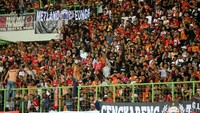 Beberapa suporter Persija memberikan komando dari atas pagar pembatas tribun.