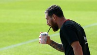 Tekun berlatih, megabintang Barcelona Lionel Messi pun kehausan. Sluurrp, si pengantin baru pun menyempatkan diri minum dulu agar tak dehidrasi. (Foto: Albert Gea/Reuters)