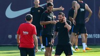Valverde memanggil Messi, dengan Suarez terlihat memasang senyum lebar di latar belakang. Ada apa ya kira-kira? (Foto: Albert Gea/Reuters)