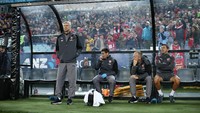 Wenger sebenarnya sudah memakai baju kasual sejak tur Australia. Dia juga memakai jaket biru gelap saat itu. Sepatunya masih berwarna hitam dengan foam putih. (Mark Metcalfe/Getty Images)
